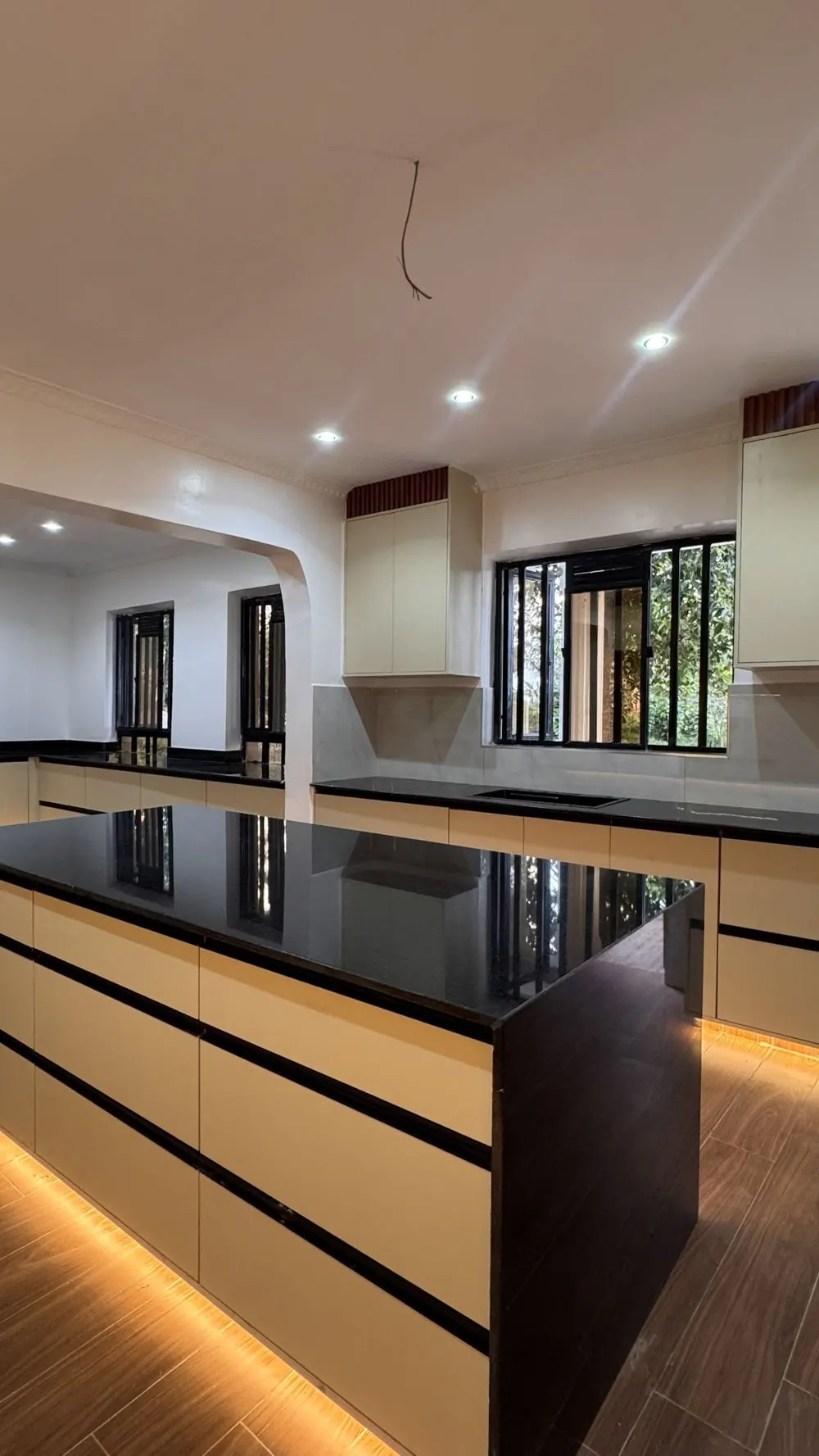 The garden-side run of cream cabinetry and black granite