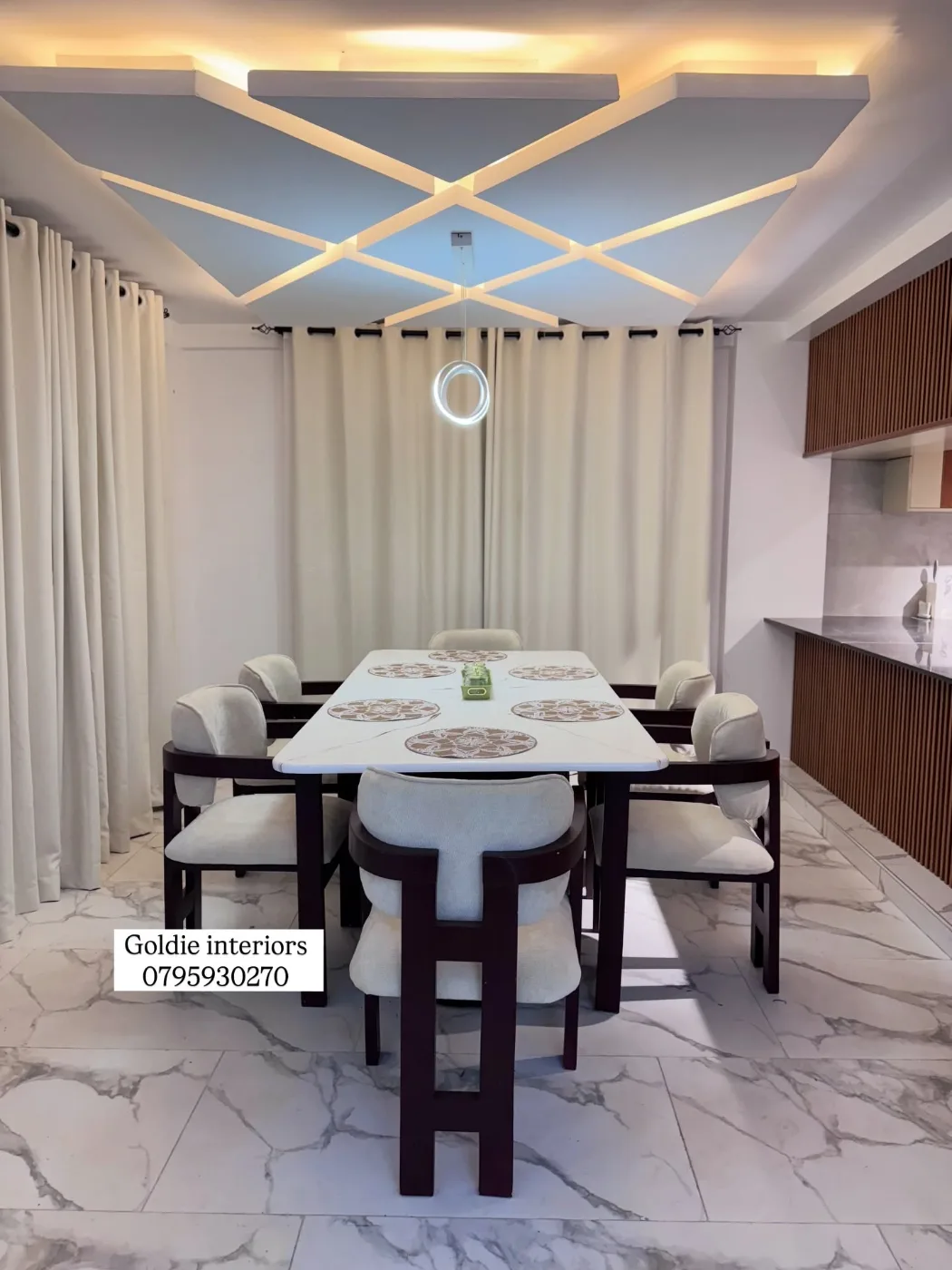 Dining table with cream upholstered chairs under an X-pattern gypsum ceiling lit from behind, with cream curtains and a ring pendant